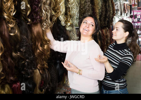 Due clienti sorridenti acquisto di allungamento dei capelli in salone Foto Stock