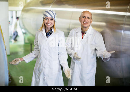 Agriturismo i dipendenti che lavorano nel latte crudo settore di allevamento di bestiame Foto Stock
