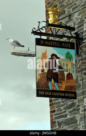 Il vecchio custom house casa pubblica di proprietà di St Austell brewery in Padstow sulla North Cornish Coast. seagull seduto su un pub firmare al mare. Foto Stock