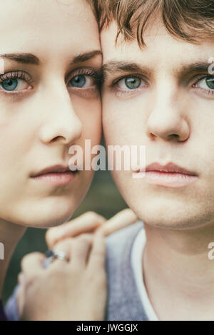 Close up di un giovane coupole facce con gli occhi blu fissando all'aperto Foto Stock