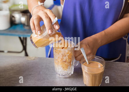 Hot Thai tè latte vetro mano versare birra misto sulla firma ghiacciata bevanda locale Foto Stock