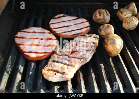 Un grill Lamb Chop, prosciutto bistecche e patate intere Foto Stock