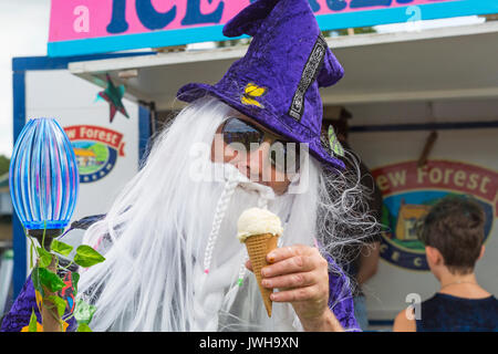 Burley, Hampshire, Regno Unito. 12 Ago, 2017. New Forest Fairy Festival. Masse di fate e folletti, cosparso con polvere di fata, scenda su di Burley per il fine settimana per una magica incantevole festival nella nuova foresta. Uomo vestito come procedura guidata in accappatoio e hat con lunghi capelli bianchi e la barba azienda doga in una mano e gelati in un'altra. Credito: Carolyn Jenkins/Alamy Live News Foto Stock