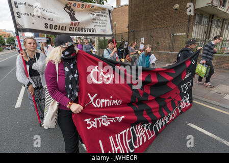 Londra, Regno Unito. Il 12 agosto 2017. Whitechapel gruppo anarchico marzo a sostegno della messa a fuoco E15 madri dal punto Ferrier in Canning Town per un rally a Tanner punto in Plaistow sottolineando il pericolo di questi due blocchi con lo stesso rivestimento come Grenfell Tower, esigente di Safe Homes, non sociale pulizia nella zona est di Londra. Poi hanno continuato a i falegnami di estate in Stratford largamente svuotata di persone di oltre dieci anni fa e intende smantellare, per un "mani circa i falegnami di Estate' evento di solidarietà contro la decantazione, Credito: Peter Marshall / Alamy Live News Foto Stock