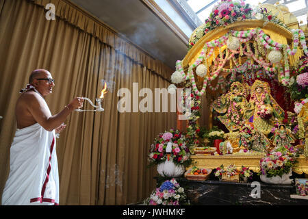 Watford, Regno Unito. 13 Agosto, 2017. Il sacerdote svolge un aarti a Bhaktivedanta Manor, gli Hare Krishna Temple a Watford per il festival di Janmashtami. Si tratta di una celebrazione della nascita di Krishna, con decine di migliaia di persone che frequentano oltre due giorni, ed è il più grande di tali eventi al di fuori dell India. Bhaktivedanta Manor è stata donata al Hare Krishna circolazione nei primi anni settanta da ex Beatle George Harrison. Credito: Dinendra Haria/Alamy Live News Foto Stock
