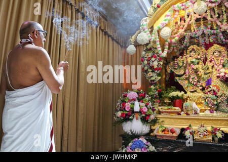 Watford, Regno Unito. 13 Agosto, 2017. Il sacerdote svolge un aarti a Bhaktivedanta Manor, gli Hare Krishna Temple a Watford per il festival di Janmashtami. Si tratta di una celebrazione della nascita di Krishna, con decine di migliaia di persone che frequentano oltre due giorni, ed è il più grande di tali eventi al di fuori dell India. Bhaktivedanta Manor è stata donata al Hare Krishna circolazione nei primi anni settanta da ex Beatle George Harrison. Credito: Dinendra Haria/Alamy Live News Foto Stock