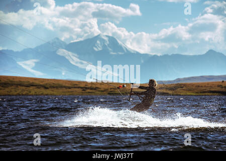 Donna kite surf nel lago di montagna Foto Stock