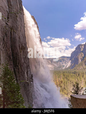 Yosemite Falls fino vicino e tiro da un unico angolo in una zona umida. Le cascate Inferiori a Yosemite con una vista della valle in background Foto Stock