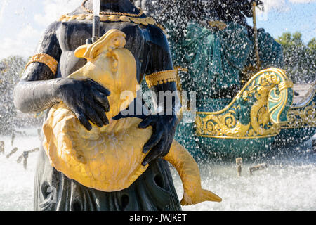 Vista ravvicinata della Fontana dei mari in piazza Concorde a Parigi con una statua di un Nereid che tiene un pesce dorato che sprende l'acqua verso l'alto. Foto Stock