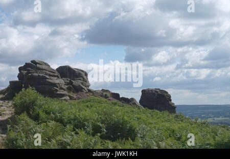 Camminando lungo la parte superiore del bordo Froggatt, Parco Nazionale di Peak District, Inghilterra Foto Stock