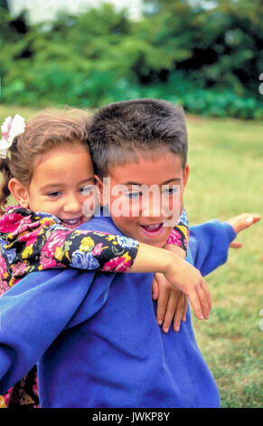 Americano asiatico i bambini divertendosi fratello giocando con la sorella più giovane Foto Stock