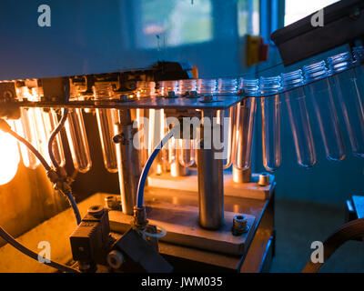 File di bottiglie in plastica a impianto di imbottigliamento. Produzione di una bottiglia piccola linea Foto Stock