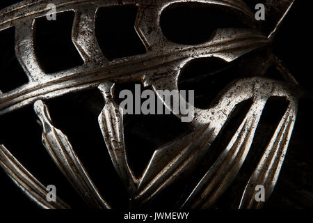 Alto contrasto close-up immagine dell'antiquariato italiano spada elsa componenti contro uno sfondo nero Foto Stock