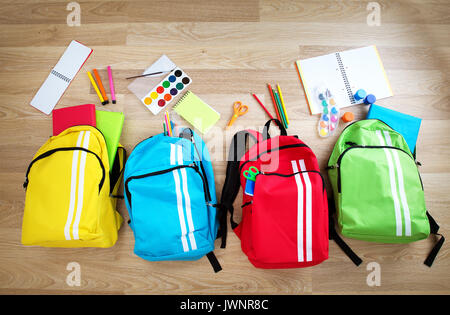 Bambini colorati schoolbags sul pavimento in legno Foto Stock