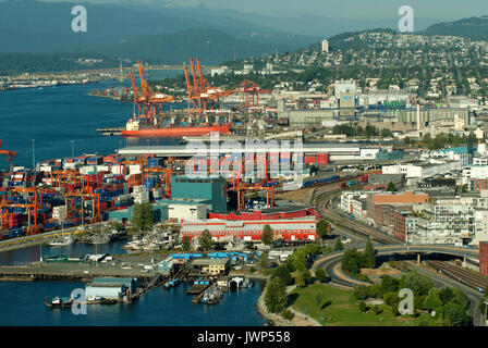 I container per il trasporto merci e gru presso il Porto di Vancouver, sullo sfondo la seconda Narrows Bridge e le montagne, Vancouver, British Columbia, Canada Foto Stock