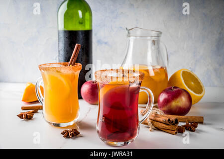 Tradizionale in autunno e in inverno le bevande e cocktail. Il bianco e il rosso autunno caldo sangria piccante con anice, cannella, mela, arancio, vino. In tazze di vetro, whi Foto Stock