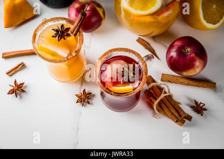 Tradizionale in autunno e in inverno le bevande e cocktail. Il bianco e il rosso autunno caldo sangria piccante con anice, cannella, mela, arancio, vino. In tazze di vetro, whi Foto Stock