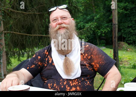 Mann mit langem Bart lächelt, beim Kaffee trinken Foto Stock