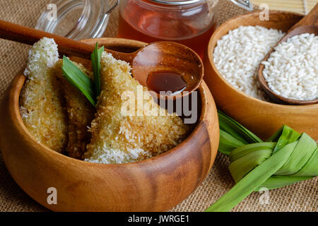 Torta Lupis o Kue Lupis dall Indonesia nel recipiente di legno Foto Stock