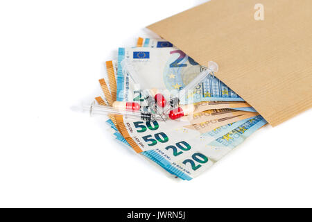 Siringhe e le banconote in euro le fatture in busta marrone. Costo della salute, della medicina, il traffico di droga. Close-up. Foto Stock