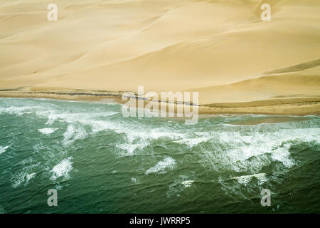 Oceano atlantico incontra il deserto del Namib le onde e le dune di sabbia orizzontale Foto Stock