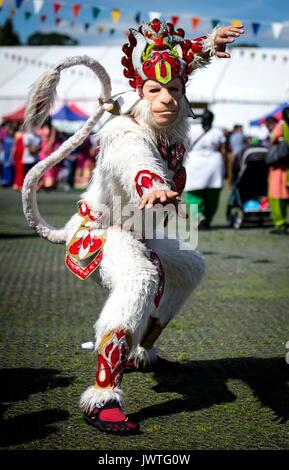 Un uomo vestito come Indù dio scimmia Hanuman durante il Janmashtami festival indù al Hare Krishna Bhaktivedanta Manor in Watford, un annuale festival indù che celebra la nascita di Krishna, ottavo avatar di Vishnu. Foto Stock