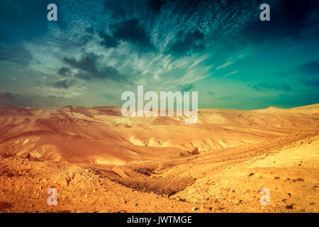 Deserto di montagna con colorati cielo nuvoloso. Deserto della Giudea in Israele al tramonto Foto Stock