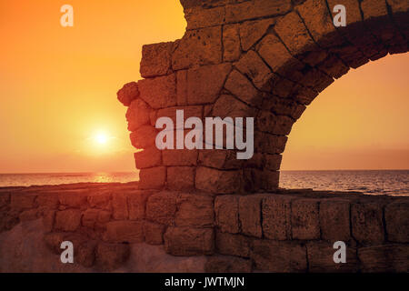 Acquedotto nella città antica Cesarea al tramonto Foto Stock