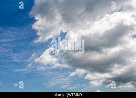 Pesante nuvola grigio su un Cielo di estate blu. drammatico sfondo meteo con dinamica disposizione cloud Foto Stock