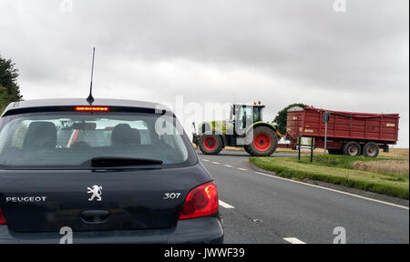 Attende di traffico per un trattore agricolo a unirsi alla A303 trunk road nel sud ovest dell'Inghilterra. Foto Stock