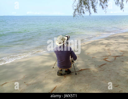 L'uomo prendendo foto sulla spiaggia sabbiosa della provincia di Trat della Thailandia Foto Stock