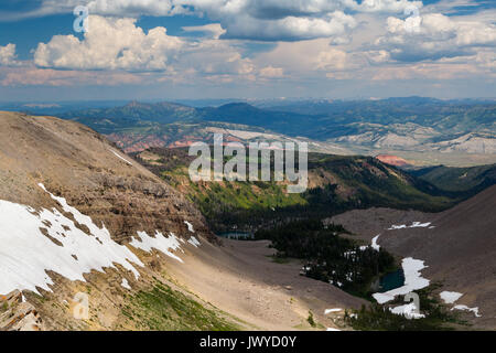 Avanzi di neve dalla stagione invernale aggrappati alle scogliere e rocce blu sopra il minatore lago sotto la cima del sonno indiano del Gros Ventre Mou Foto Stock