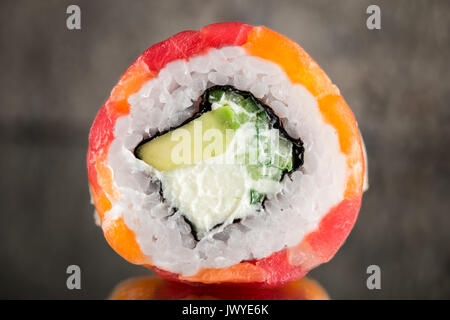 Rotolo realizzato con tonno, salmone e capesante su sfondo di calcestruzzo Foto Stock