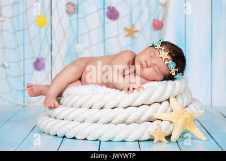 Chiudere ritratto di un sonno ragazza neonata nella cerchiatura marittimo di stelle marine e perle Foto Stock