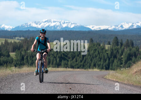 Woman Mountain bike una strada in Wallowa - Whitman National Forest, Oregon. Foto Stock