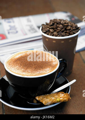 Cappuccino con cannella con pasti da asporto coppa piena di fagioli ,quotidiano e biscotti Foto Stock