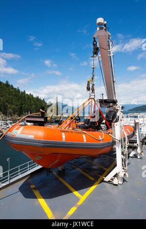 Un arancione Zodiac scialuppa di salvataggio sul ponte della BC Ferries Traghetto per trasporto auto e passeggeri regina di Cowichan a baia a ferro di cavallo della Columbia britannica in Canada Foto Stock