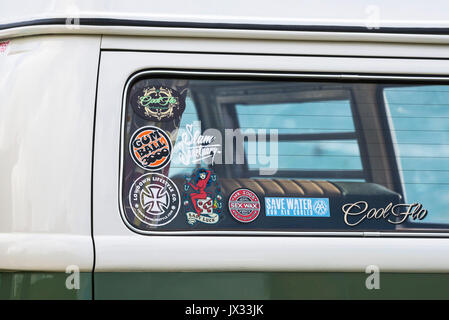 Un primo piano di adesivi vari e segni sulla finestra di una VW camper. Foto Stock