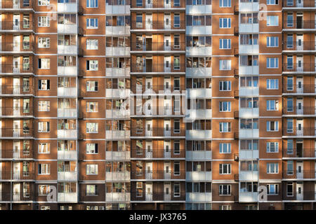 Frammento di uno dei seriale ad alta edifici di appartamenti nella periferia di Mosca con il tramonto riflesso sulla parete e windows. Nuova costruzione Foto Stock