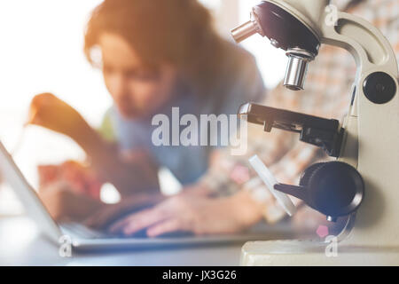 Chiusura del microscopio che in piedi sulla tavola. Foto Stock