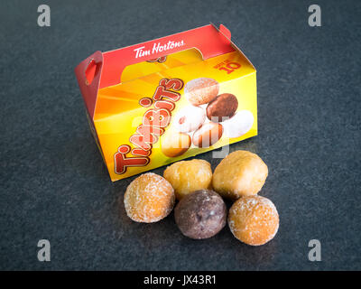 Timbits (fori di ciambella, donut fori) da Tim Hortons, un canadese popolare ristorante fast food chain. Foto Stock