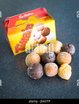 Timbits (fori di ciambella, donut fori) da Tim Hortons, un canadese popolare ristorante fast food chain. Foto Stock