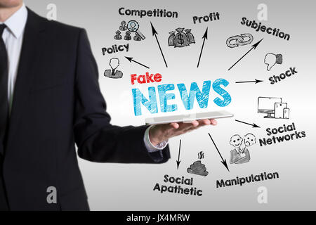 Fake News concept. Uomo in possesso di un computer tablet. Foto Stock