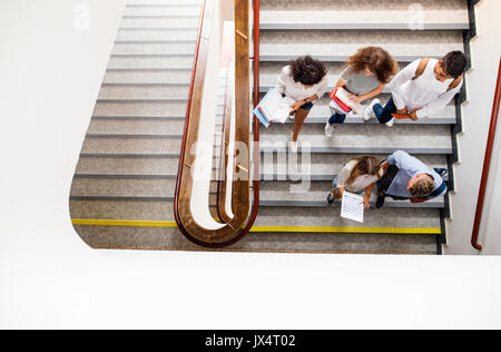 Gruppo di adolescenti attraenti gli studenti a scuola a piedi giù per le scale. Foto Stock