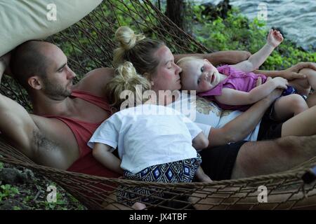 Famiglia relax su una amaca dalla riva del lago di Ozark, MO Foto Stock