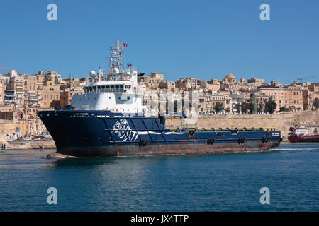 La piattaforma recipiente di alimentazione (PSV) o alimentazione offshore Nave OOC Tiger passa per la città fortificata di La Valletta che entra in Malta il Grand Harbour Foto Stock