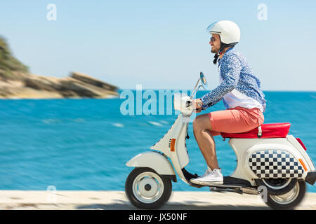 Uomo bello in posa su uno scooter in un contesto di vacanza. Street Moda e  stile Foto stock - Alamy