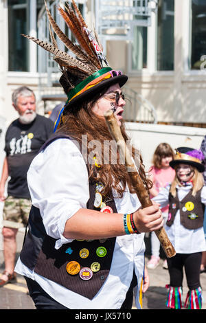 Le giovani donne, nella sua 20s, folk ballerino, ballando con Morris lato, Dead Horse Morris, durante la Broadstairs Settimana della musica folk. Indossare occhiali da sole e cappello nero con piuma e tenendo un pole mentre balli. Foto Stock