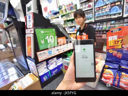 Hong Kong, Cina. 14 Ago, 2017. Un giornalista di esperienze il pagamento mobile di utensile Wechat pagare in un 7-Eleven convenience store in Hong Kong, Cina del Sud, 14 agosto 2017. Oltre 900 negozi di 7-Eleven in Hong Kong hanno recentemente introdotto il pagamento WeChat. Credito: Wang Xi/Xinhua/Alamy Live News Foto Stock