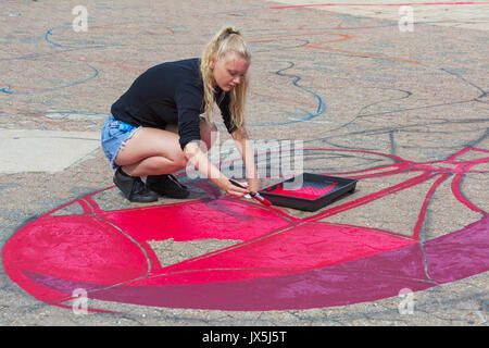 Bournemouth Dorset, Regno Unito. Il 15 agosto, 2017. Grandi opere di Spiderman sta prendendo forma sul molo approccio, disposti da Ambassadeur Art. Giovane donna Uomo Ragno di verniciatura con vernice rossa con spazzola di vernice e il vassoio. Credito: Carolyn Jenkins/Alamy Live News Foto Stock